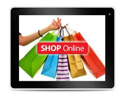 Een hand met kleurrijke tassen en de tekst "SHOP Online" op een tablet scherm.